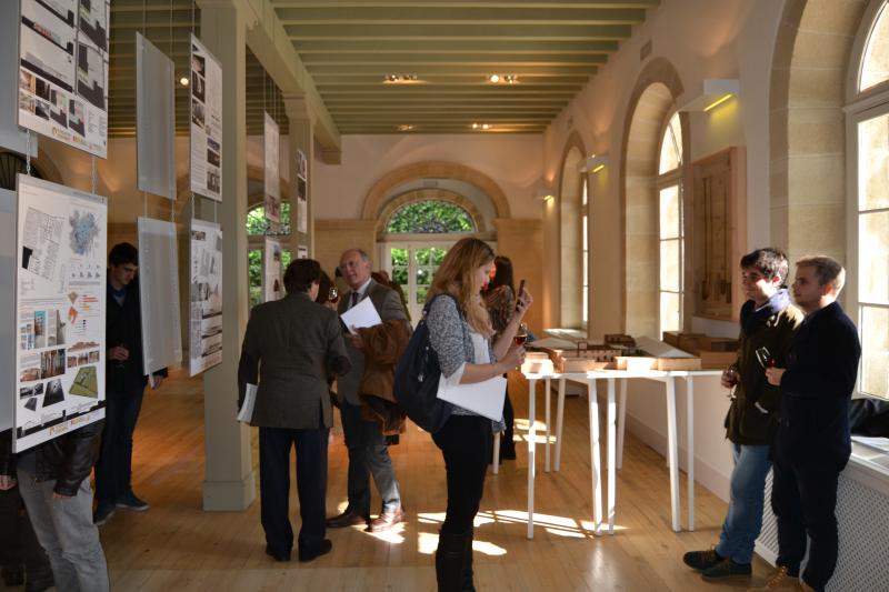 Aparece un alumno de Arquitectura presentando la maqueta de su proyecto, al presidente de la Fundación y a los medios de comunicación entre otros